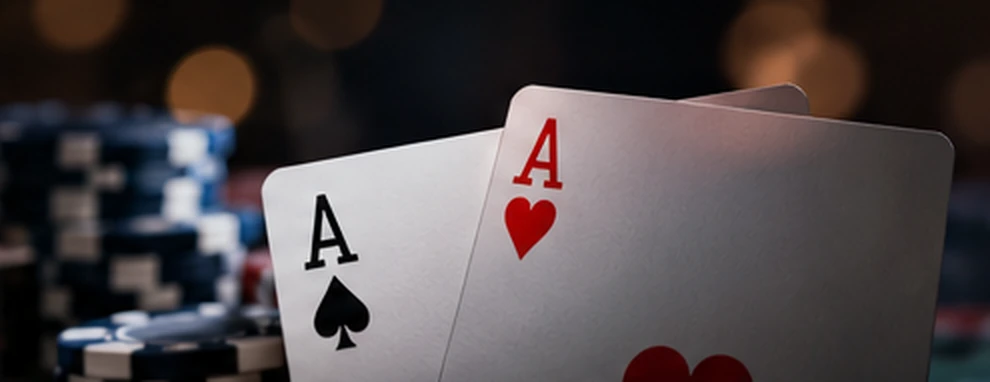 Two aces photographed beside stacks of gaming chips.